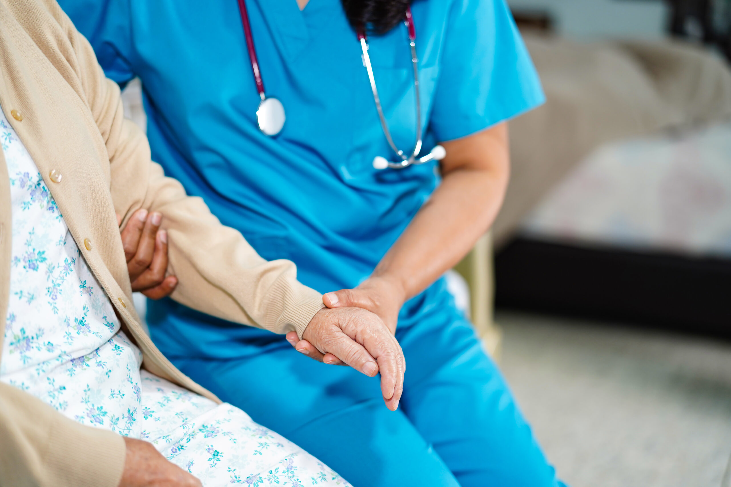 nurse holding patient’s hand during care, representing compassion and responsibility in building a healthcare company
